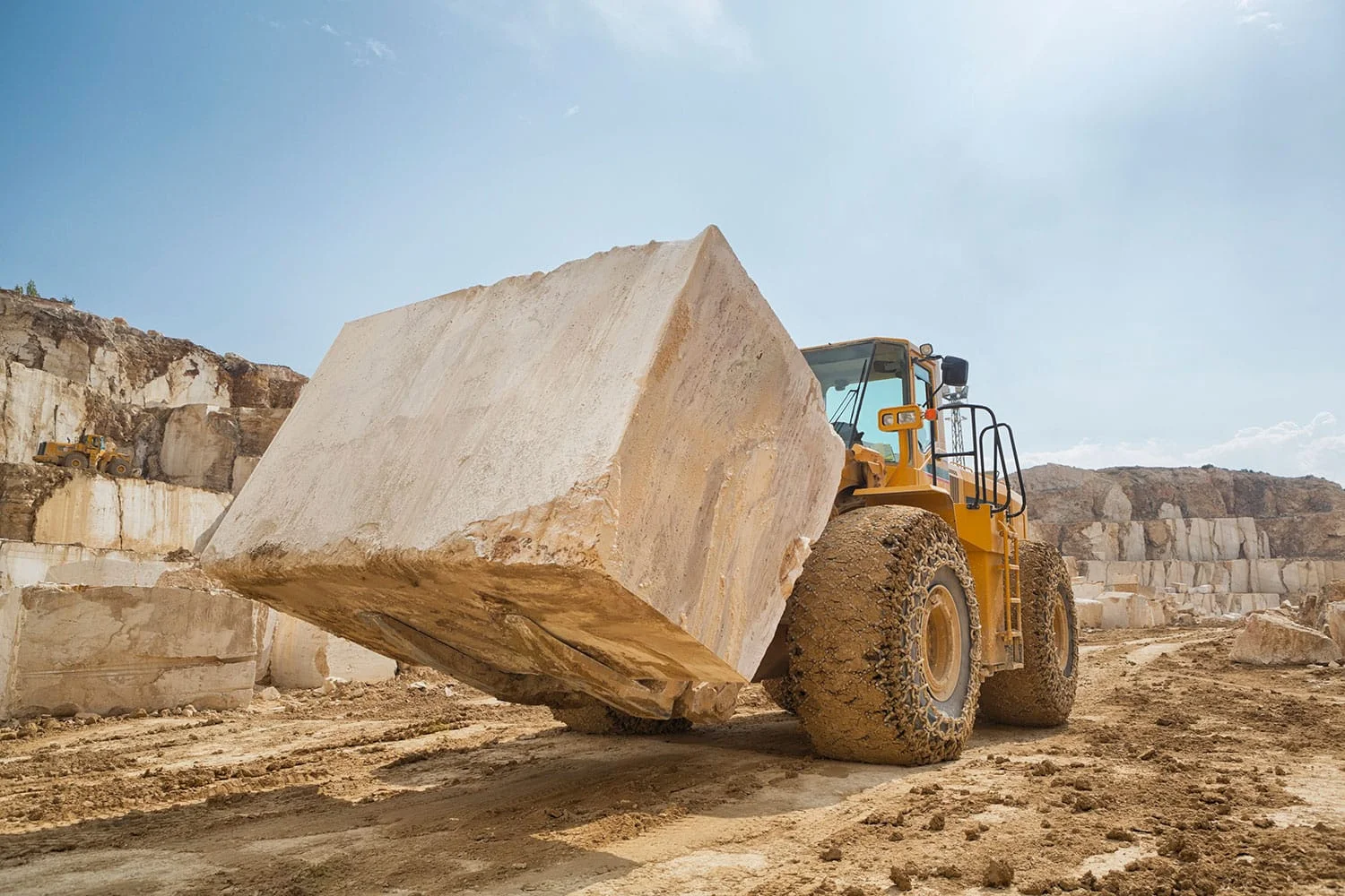 Heavy machinery lifting large marble block at a Spanish quarry – natural stone extraction by Natural Stone Spain.