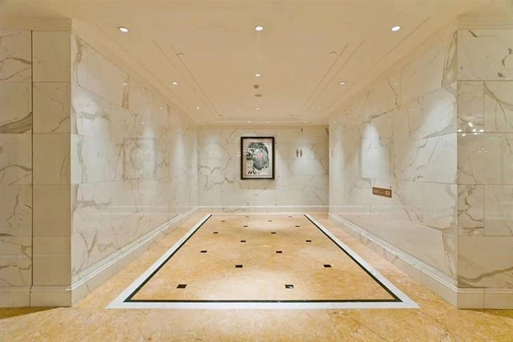Luxurious interior space with polished Crema Marfil Marble flooring and wall accents – timeless elegance by Natural Stone Spain.