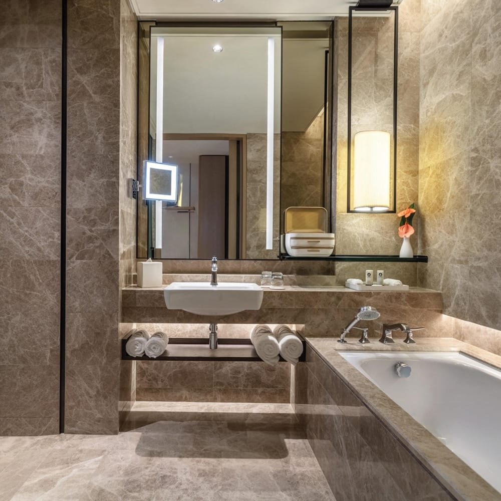 Modern bathroom interior featuring polished brown marble walls and vanity – luxurious stone design by Natural Stone Spain.