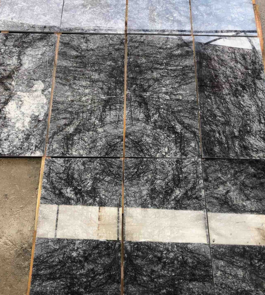 Textured Black Pearl marble tiles laid out for inspection – bold natural patterns ideal for exterior and interior use by Natural Stone Spain.
