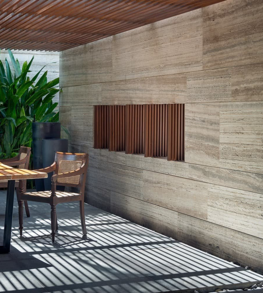 Modern outdoor seating area with Classic Travertine wall cladding – natural warmth and texture by Natural Stone Spain."