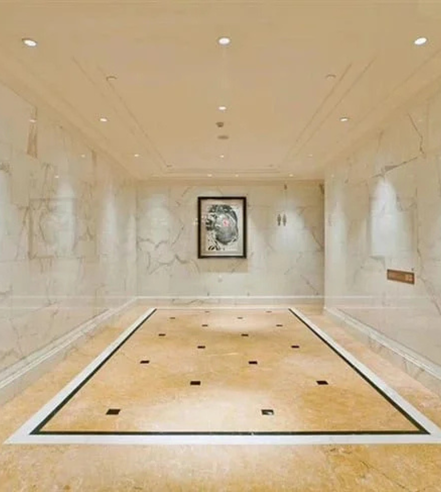 Elegant gallery-style interior with Crema Valencia marble inlay and white marble walls – luxurious stone combination by Natural Stone Spain.