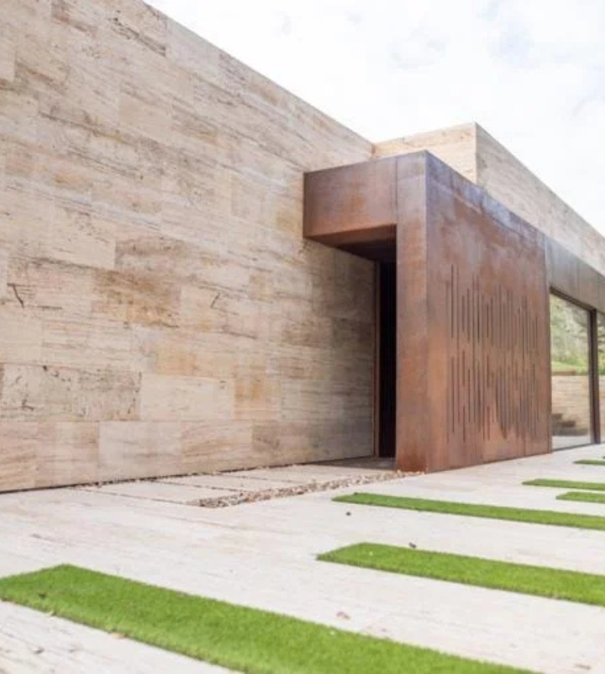 Modern architectural facade clad in Gold Travertine with minimalist landscaping – elegant natural stone exterior by Natural Stone Spain