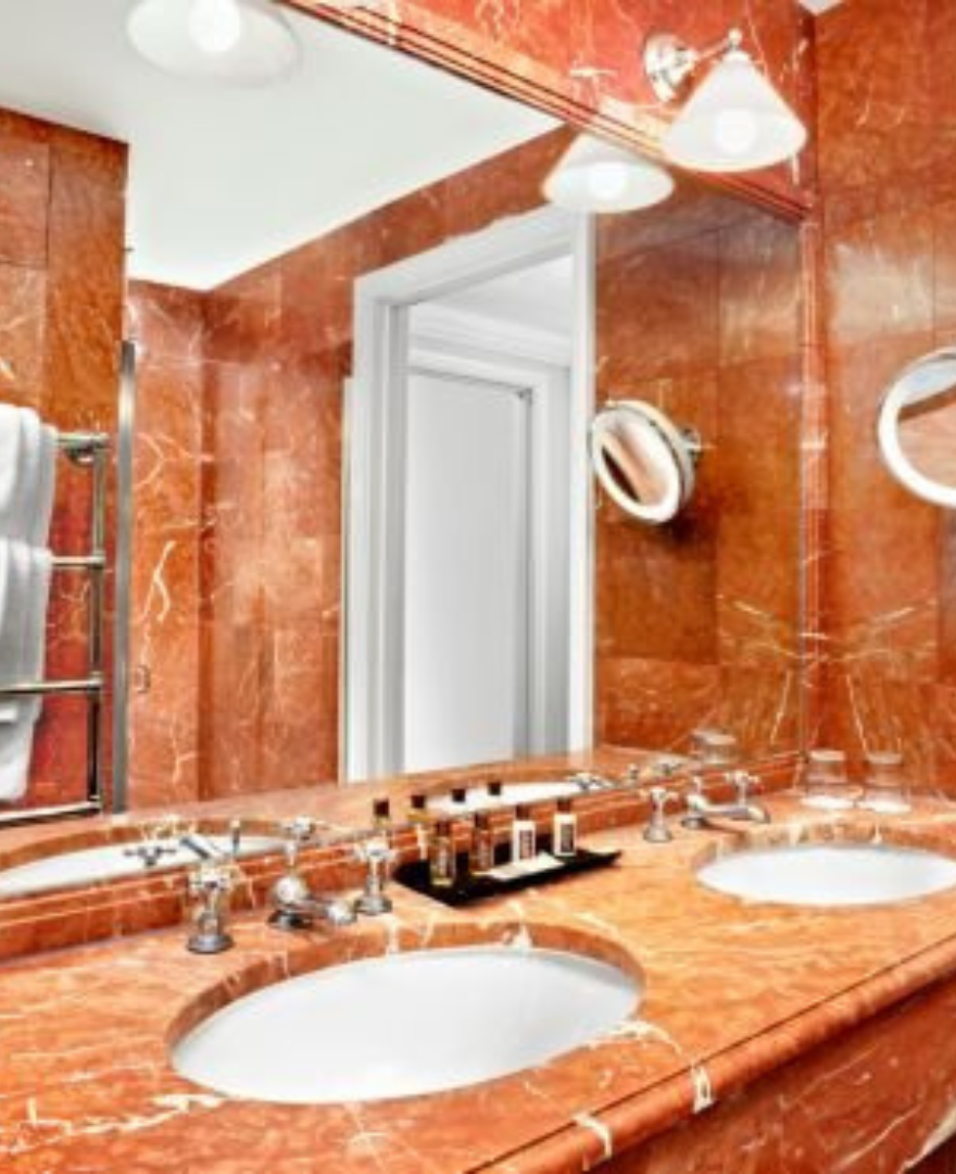 Luxurious bathroom with Red Alicante Marble countertops and wall cladding – vibrant natural stone finish by Natural Stone Spain.