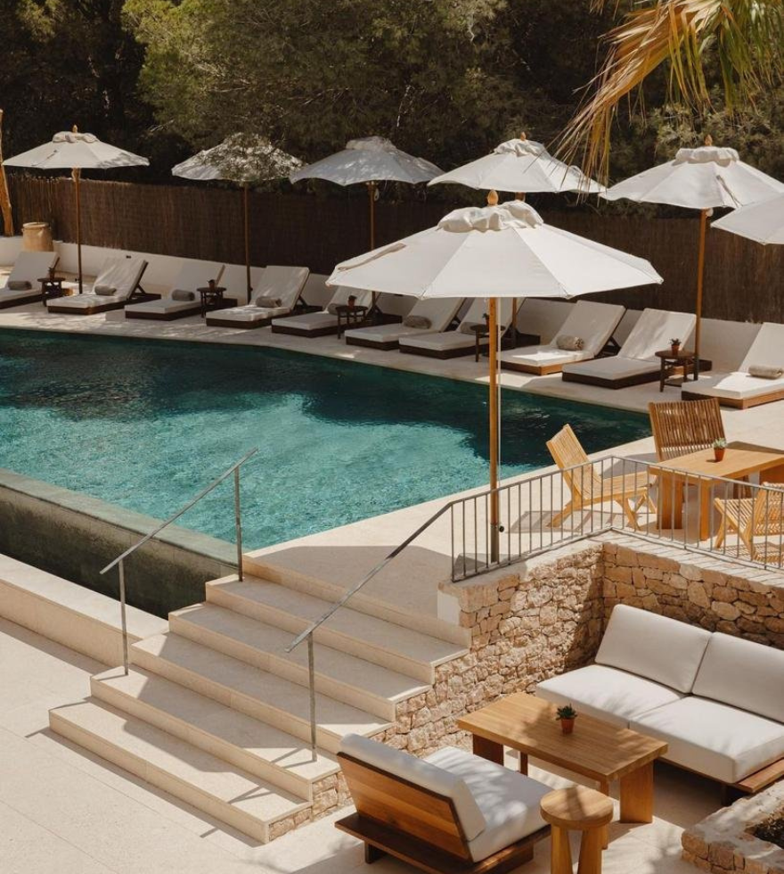 Elegant outdoor poolside area with light-toned natural stone paving – luxurious resort setting by Natural Stone Spain.