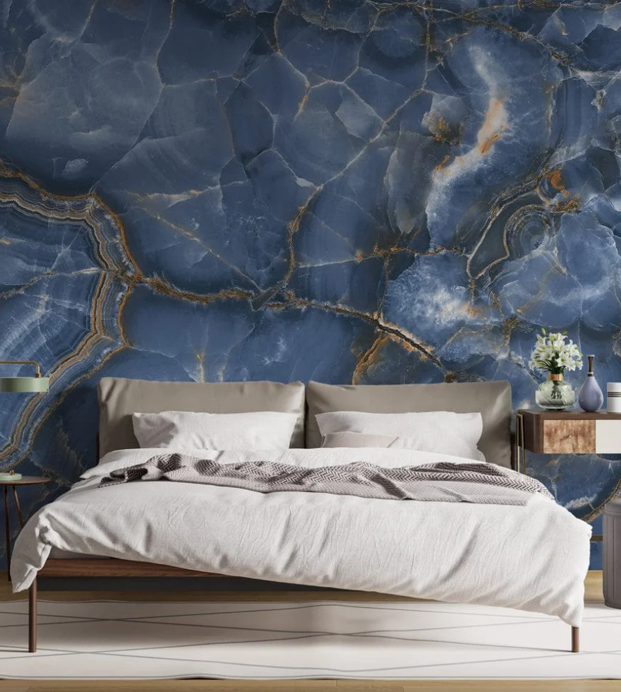 "Modern bedroom interior with a dramatic Blue Onyx marble feature wall behind the bed, showcasing deep blue hues with golden veining, adding luxury and depth to the space.