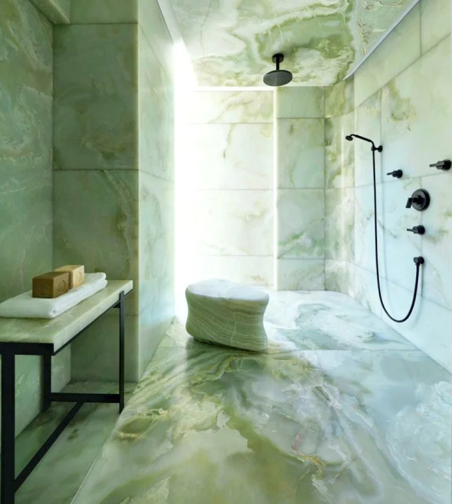 Luxurious walk-in shower and bathroom wrapped in elegant Green Onyx Marble, showcasing soft green and white veining for a tranquil, spa-like ambiance