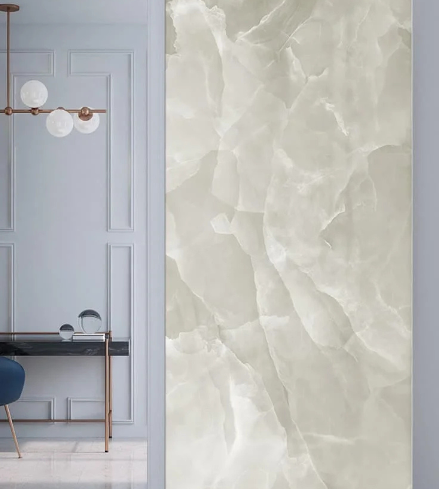 Elegant interior with a White Onyx marble feature wall showcasing translucent patterns, paired with a minimalist vanity and soft blue wall paneling.